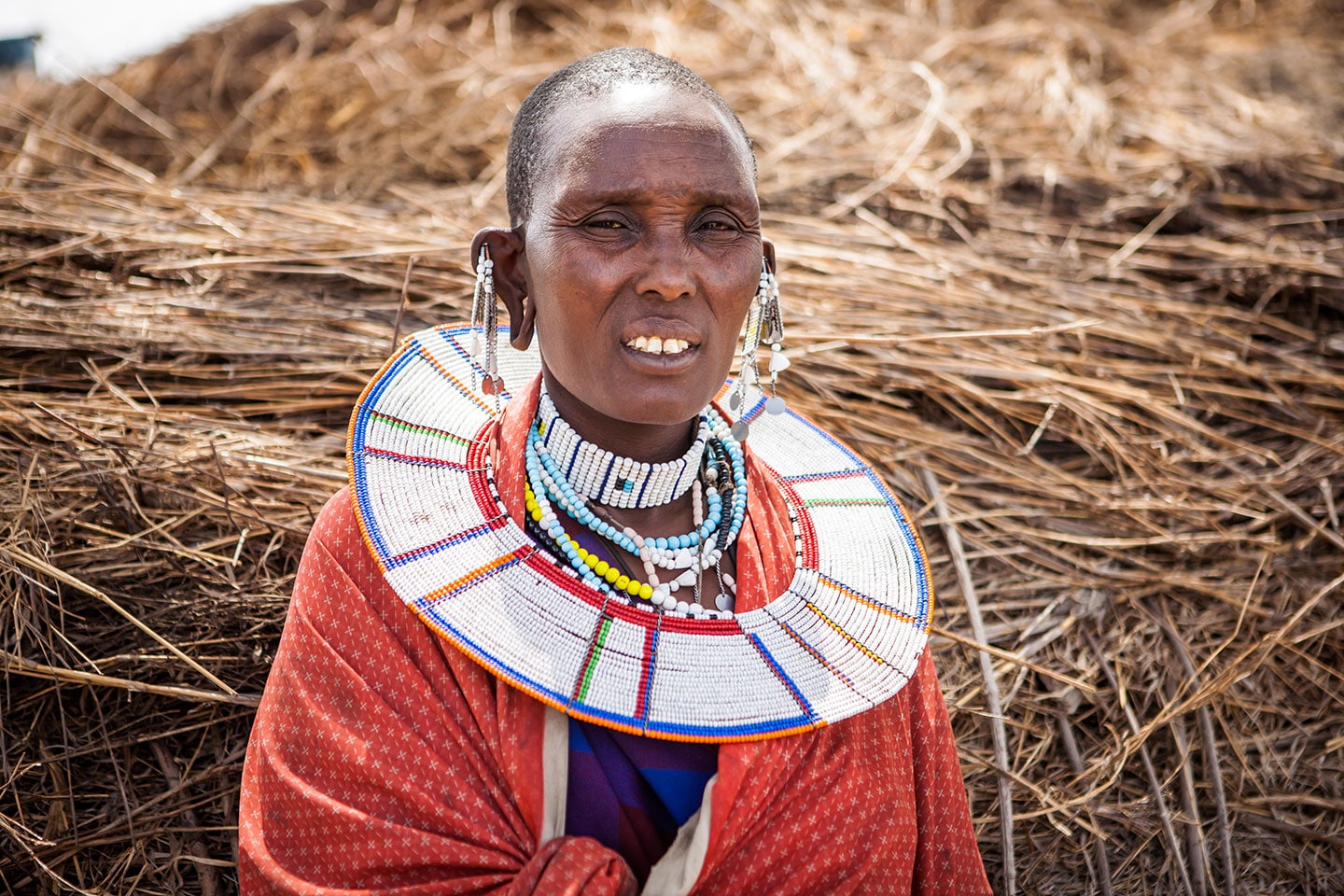 Travel photography of a Maasai woman in her traditional outfit in a Maasai village in Kenya, Africa