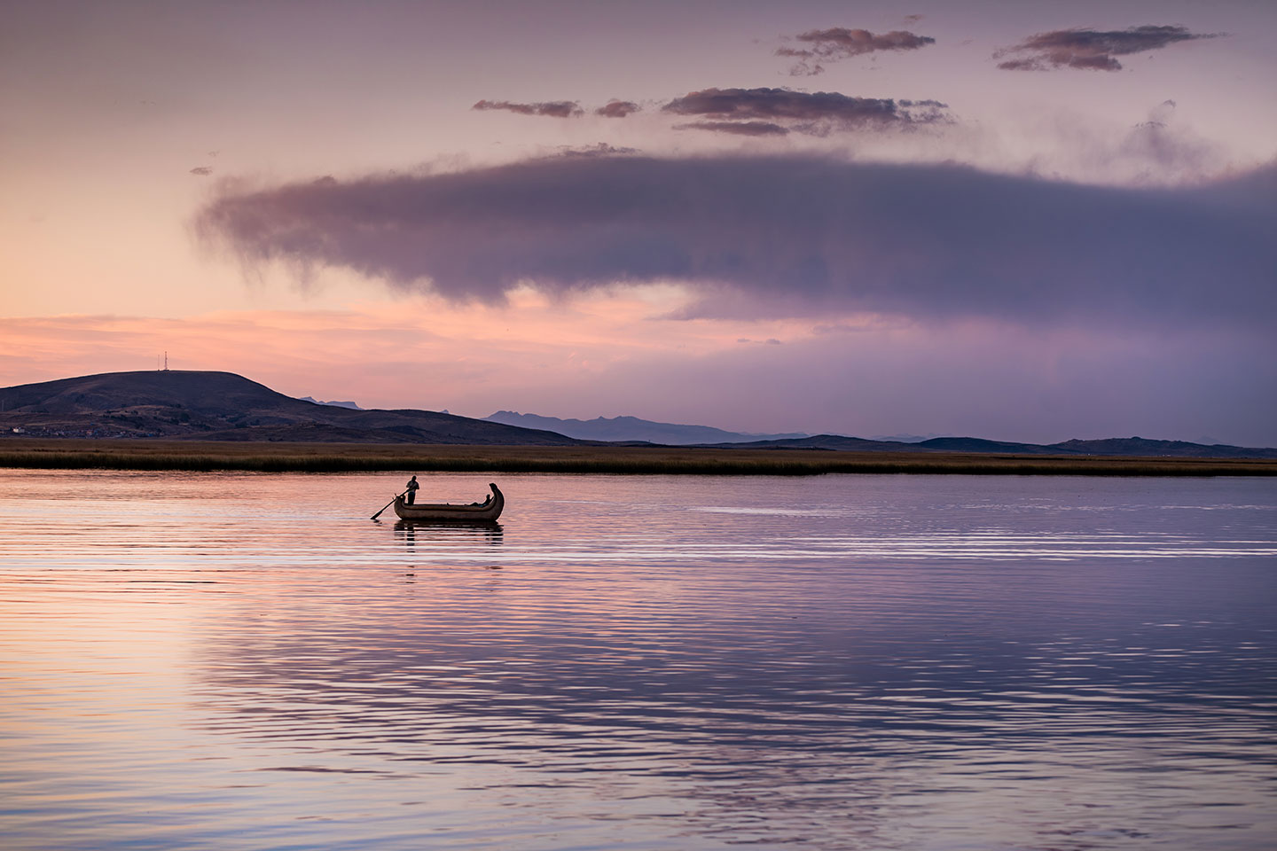 Lake Titicaca, Peru A local fisherman on a reed boat at Lake Titicaca, Peru at sunset