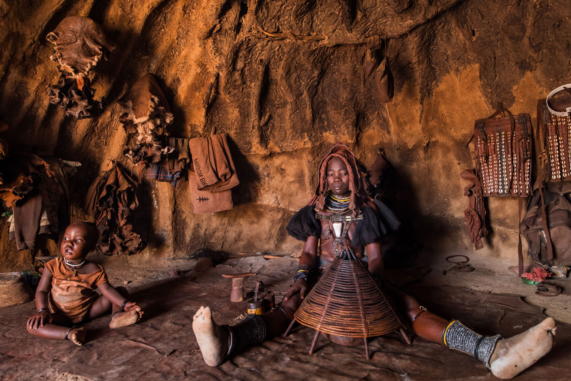 Himba girl cooking inside a hut in a Himba village in Namibia