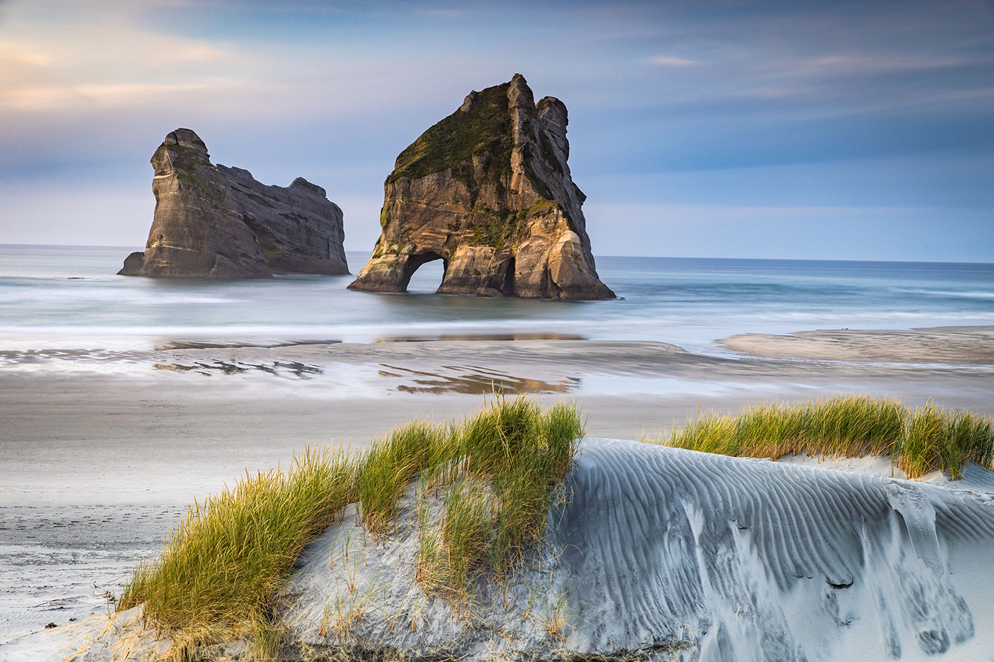 Wharariki beach Rock formation and white sand dunes at Wharariki beach, New Zealand
