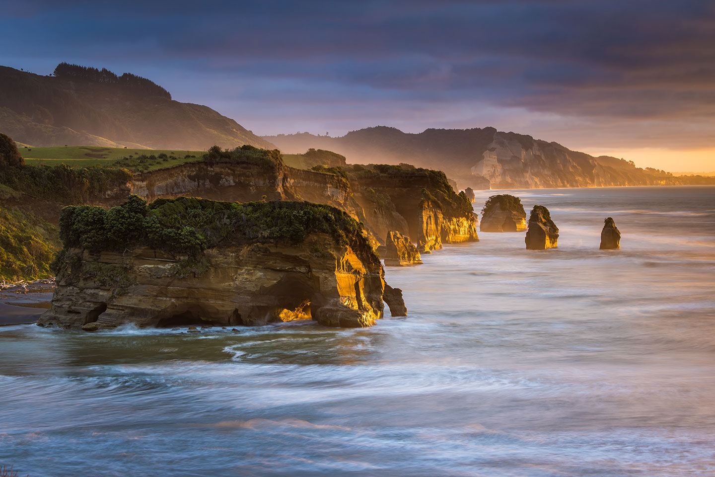 Tongapōrutu Sunset over the Tongapurutu sea stacks in New Zealand, also known as the three sisters
